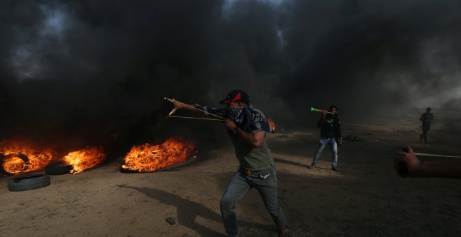 Un manifestante usa un tirachinas para arrojar piedras durante una protesta en la que los palestinos reclaman el derecho a regresar a su patria, en la frontera entre Israel y Gaza. REUTERS / Ibraheem Abu Mustafa