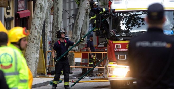Los bomberos del Ayuntamiento tratan de localizar entre los escombros del edificio derrumbado a dos obreros. - EFE