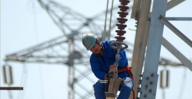 Un trabajador instala nuevas líneas de alto voltaje en una torre de electricidad. EFE/Archivo