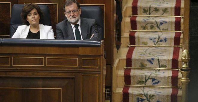 La vicepresidenta del Gobierno, Soraya Sáenz de Santamaría, y el presidente Mariano Rajoy siguen la votación. (EFE)