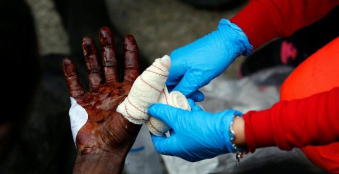 Uno de los inmigrantes es atendido por las heridas tras cruzar la valla - REUTERS