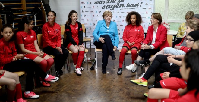 La canciller alemana Angela Merkel y la secretaria de Estado Annette Widmann-Mauz conversan con las jugadoras del SV Rot-Weiss Viktoria Mitte 08 como parte del evento 'Deportes e integración' en Berlín. REUTERS/Kay Nietfeld