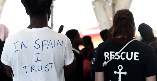 Un migrante con una camiseta en la que ha escrito, en inglés, 'En España confío', espera a desembarcar del buque Aquarius en el puerto de Valencia. REUTERS /Kenny Karpov/SOS Mediterranee