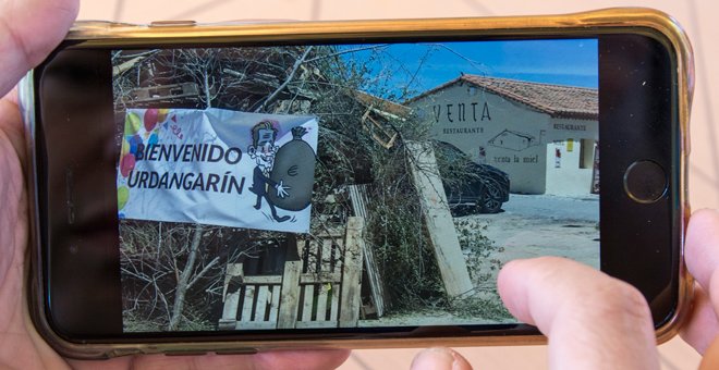 Un vecino muestra una hoguera de San Juan con una pancarta que da la bienvenida a Urdangarin. / REPORTAJE GRÁFICO: J. GÓMEZ