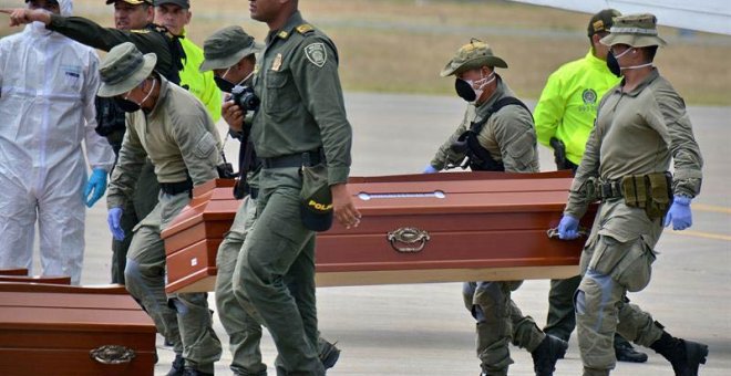 Personal de la Policía ayuda hoy, viernes 22 de junio de 2018, en Cali (Colombia), a cargar los ataúdes con los cuatro cuerpos hallados por las autoridades colombianas en una zona selvática. (ERNESTO GUZMÁN Jr. | EFE)