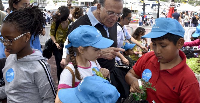 Isidro Fainé conversando con unos niños en el acto del Día del Voluntariado La Caixa en Barcelona.