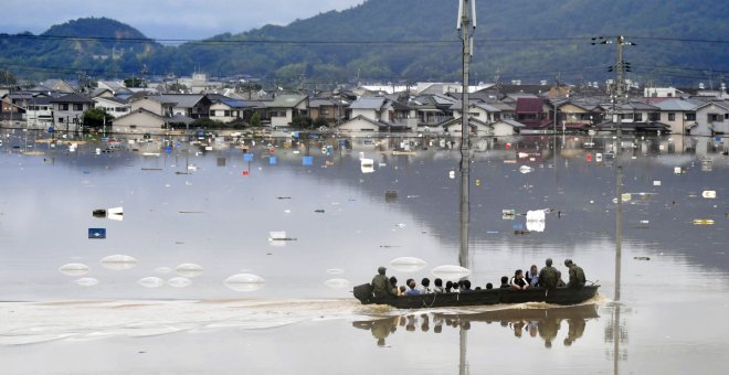 Ciudadanos japoneses son rescatados por miembros del Ejército tras quedar atrapados a cauda de las lluvias torrenciales./REUTERS