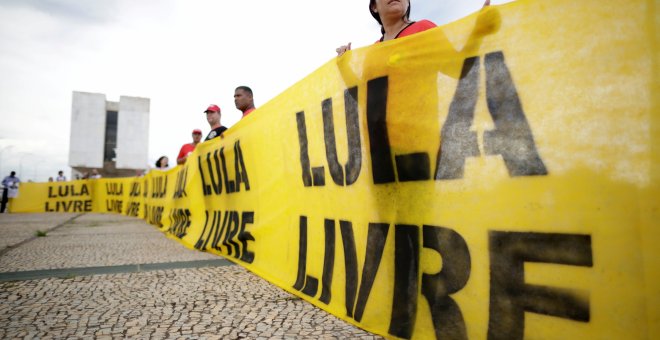 Varias personas sujetan una pancarta que pide la libertad del expresidente Lula./REUTERS