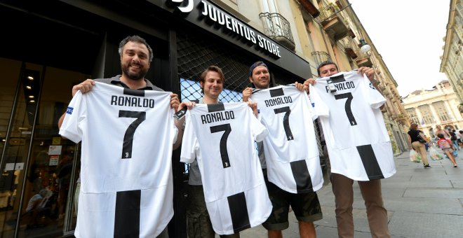 Varios hinchas de la Juventus posan con la camiseta del equipo con el nombre y el número de Ronaldo tras confirmarse su traspaso. /REUTERS