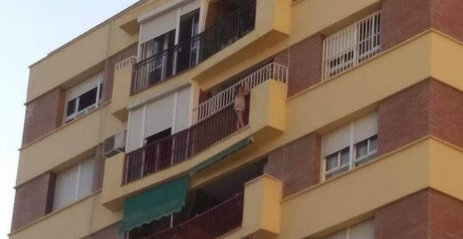 La niña de cinco años, agarrada a la parte externa del balcón. (EP)