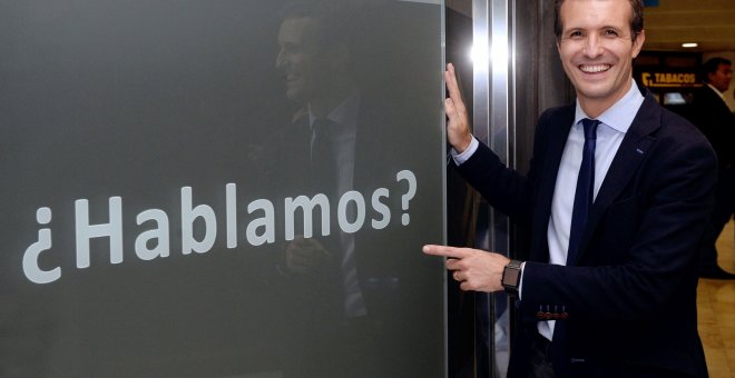 El candidato a la Presidencia del PP Pablo Casado posa junto una publicidad de un establecimiento comercial, en el que se puede leer “¿Hablamos?”. EFE/Nacho Gallego
