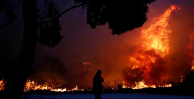 Un hombre observa las llamas en la ciudad de Rafina, cerca de Atenas.(COSTAS BALTAS | EFE)