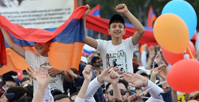 Dos jóvenes armenios portando una bandera durante una concentración en Yereván, Armenia. / Reuters