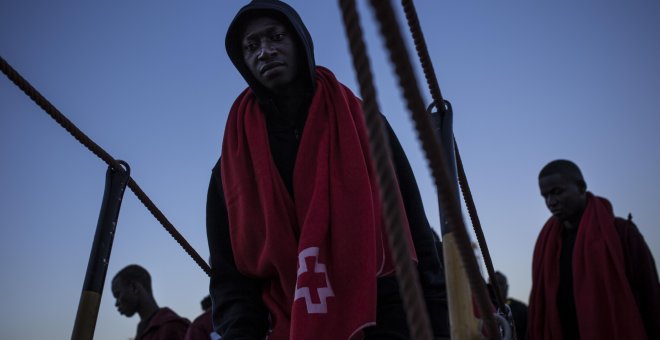 Un joven migrante sube a borde de un barco de Sasemar junto a otros 200 personas para pasar la noche tras ser rescatado de una patera durante el fin de semana. JAIRO VARGAS