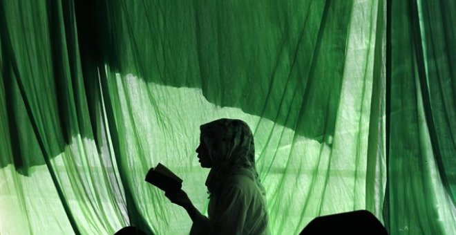 La silueta de una mujer leyendo un libro en Indonesia./REUTERS