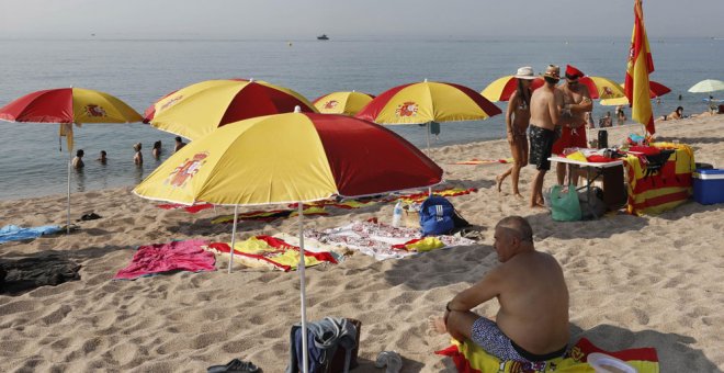 Sombrillas y toallas de la bandera de España en la playa de Arenys de Mar, en Barcelona. EFE