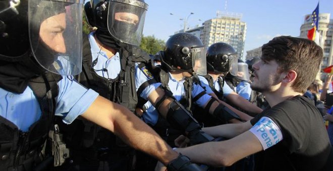 Un manifestante se encara con la policía durante las protestas en Bucarest | EFE