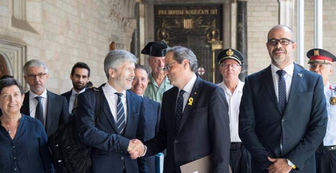 El presidente de la Generalitat,Quim Torra, junto al conseller de Interior Miquel Buch, a la detrecha, saluda al ministro de Interior, Fernando Grande-Marlaska. (MARTA PÉREZ | EFE)