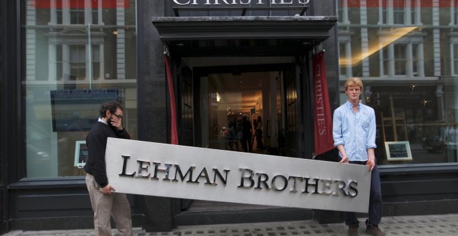 Dos empleados sujetan el letrero de la empresa Lehman Brothers. REUTERS/Andrew Winning