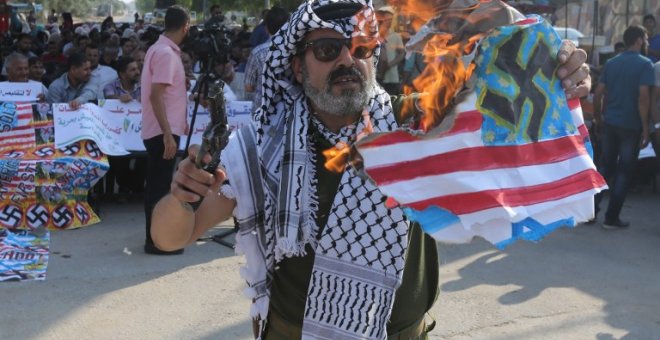 Un palestino quema una bandera de Estados Unidos en una protesta en el paso de Erez contra la decisión de la Administración Trump de suspender la financiación a la UNRWA. - AFP