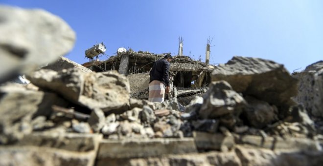 Un hombre busca entre los escombros de un edificio derruido tras un ataque aéreo de Arabia Saudí en Saná, la capital de Yemen. - AFP