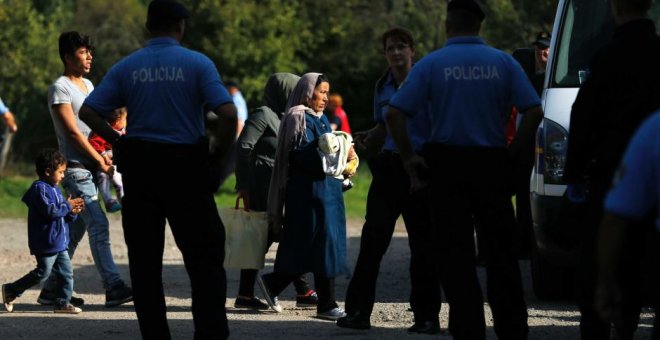 Agentes de la Policía croata escolta na varios migrantes. - REUTERS