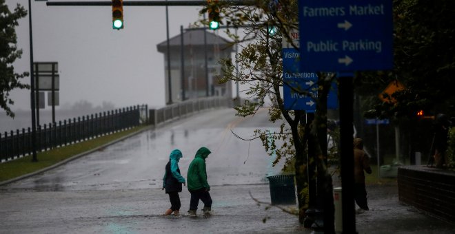 La gente camina en una calle local cuando el agua del río Neuse comienza a inundar viviendas en Carolina del Norte, /REUTERS / Eduardo Muñoz