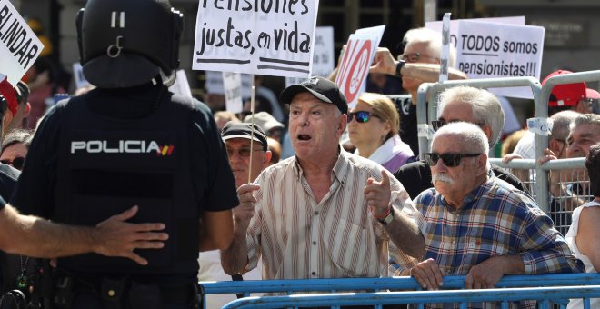 Grupos de pensionistas que se concentraron en el Congreso de los Diputados pidiendo mejoras en sus prestaciones intentan romper el cordón policial intentaba impedir su paso hasta la cámara donde hoy estaba prevista una reunión del Pacto de Toledo. EFE/Bal