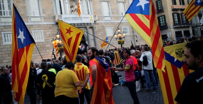 Decenas de independentistas se concentran en la Plaza Sant Jaume para evitar que policías nacionales y guardias civiles se manifiesten. | Jon Nazca / Reuters