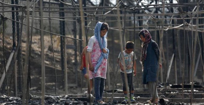 Personas refugiadas en los escombros de su refugio tras una incendio en el campo de refugiados de Moria, en la isla griega de Lesbos.- REUTERS/ARCHIVO