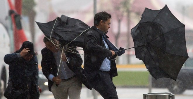 La gente sufriendo el mal tiempo en Málaga y peleándose con sus paraguas./ EFE
