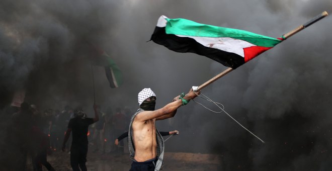 Un manifestante ondea una bandera de Palestina durante las protestas en la frontera con Israel en Gaza del viernes 26 de octubre. Mohammed Salem/REUTERS