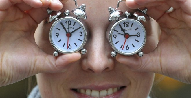 Imagen de archivo de una mujer con dos relojes con el cambio de hora. EFE/Andras Gebert