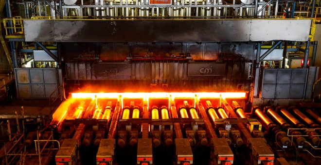 Una placa de acero al rojo vivo pasa a través de una prensa en la planta de ArcelorMittal en Gante, Bélgica. REUTERS / Yves Herman