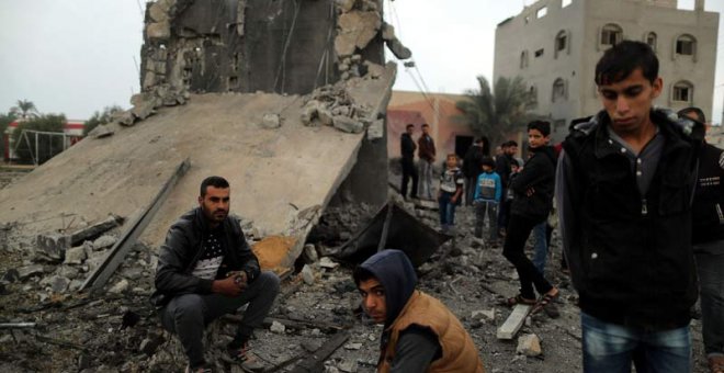 Un grupo de jóvenes palestinos observa los restos de un edificio destruido por la aviación de Israel. (SUHAIB SALEM)