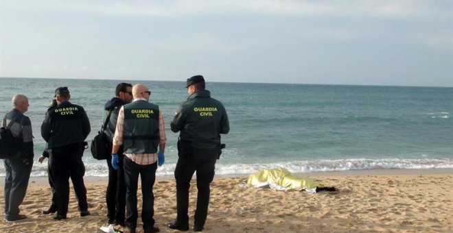 Agentes de la Guardia Civil junto al cadáver hallado este viernes en las inmediaciones de la playa del Faro de Trafalgar (Cádiz) que eleva a 20 el número de víctimas mortales del naufragio de la patera ocurrido el pasado 5 de noviembre en la playa gaditan