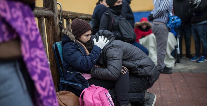 Una pareja de solicitantes de asilo espera su turno para pedir cita y comenzar sus trámites en la comisaría de Aluche (Madrid).- JAIRO VARGAS