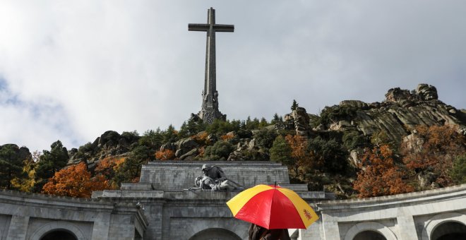 Un hombre con un paraguas con los colores de la bandera española en la explanada de la Basílica del Valle de los Caidos. REUTERS/Susana Vera