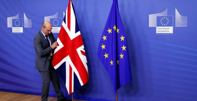 Un empleado de la Comisión Europea coloca la bandera británica.- REUTERS