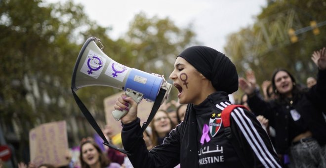 Una manifestant crida consignes feministes pel megàfon durant la marxa contra la violència masclista de Barcelona, aquest 25-N. Josel Kashila