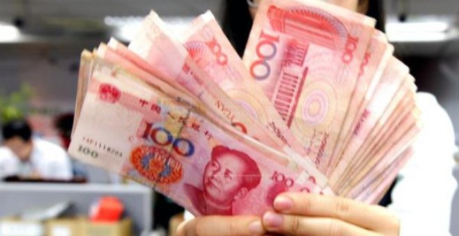 Fotografía de una trabajadora de una oficina postal con varios billetes de yuanes, en Pekín (China). Los ingresos fiscales de China aumentaron el 13,6 % en el primer trimestre del año. EFE/Archivo