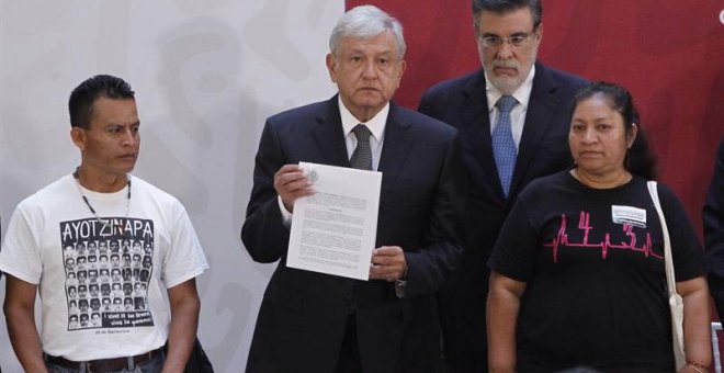 El presidente de México Andrés Manuel López Obrador  sostiene el decreto presidencial para la instalación de una Comisión de la Verdad junto a los padres de dos de las  víctimas de los 43 estudiantes de Ayotzinapa. (Sáshenka Gutiérrez | EFE)