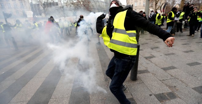 Un manifestante devuelve una granada de gas lacrimógeno a la Policía en París.- EFE/EPA/Ian Langsdon