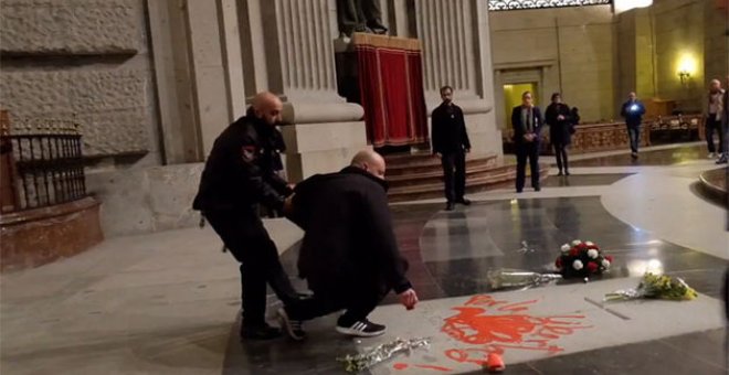 Momento en el que el artista es retirado por el equipo de seguridad cuando estaba haciendo la pintada sobre la tumba de Franco.