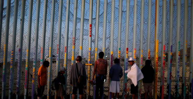 Un grupo de migrantes centroamericanos observa el muro fronterizo entre México y EEUU.- REUTERS/Mohammed Salem