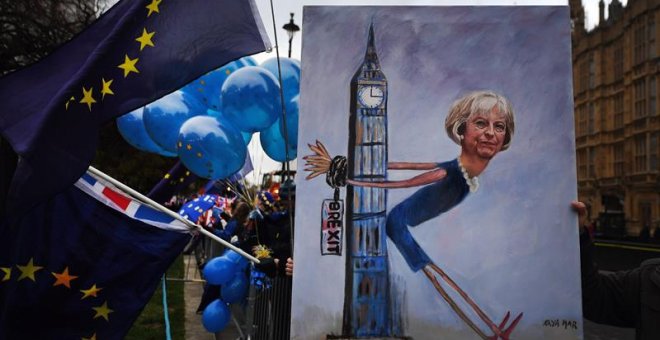 La artista Kaya Mar muestra un cuadro de la primer ministra británica Theresa May durante una manifestación en contra del brexit a las afueras del Parlamento en Londres. - EFE
