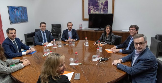 Los equipos negociadores de Partido Popular y Ciudadanos, encabezados por el presidente del PP andaluz, Juanma Moreno (i), y el líder regional de Ciudadanos, Juan Marín (2ºd), al comienzo de la reunión en el Parlamento andaluz en Sevilla para tratar sobre