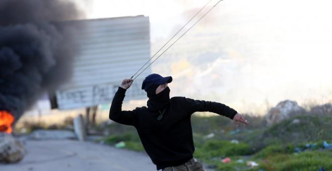 Un palestino utiliza su honda para lanzar piedras durante una protesta en el cruce de Huwara, cerca de Nablus, Cijsordania, hoy, 14 de diciembre de 2018. Cinco palestinos resultaron heridos durante las protestas, según informaciones. EFE/ Alaa Badarneh