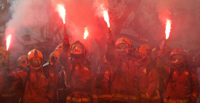 Un grupo de bomberos encienden bengalas en su protesta frente al Parlament, en Barcelona, a finales de noviembre. REUTERS/Albert Gea