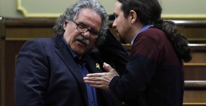 El portavoz del ERC, Joan Tardà (i), conversa con el líder de Podemos, Pablo Iglesias, durante la última sesión de control al Ejecutivo del año que celebra hoy el Congreso con la vista puesta en el Consejo de Ministros del próximo viernes en Barcelona, y